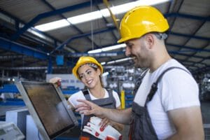 factory-worker-explaining-trainee-how-operate-industrial-machine-using-new-software-touch-screen-computer_342744-227