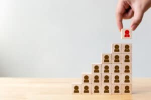 hand-putting-wood-cube-block-with-human-icon-top-staircase_20693-339