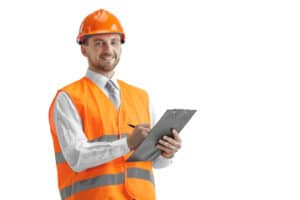 The builder in a construction vest and orange helmet standing on white studio background. Safety specialist, engineer, industry, architecture, manager, occupation, businessman, job concept